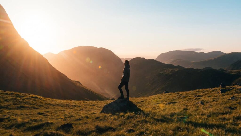 Photo of a person looking at the sun rise