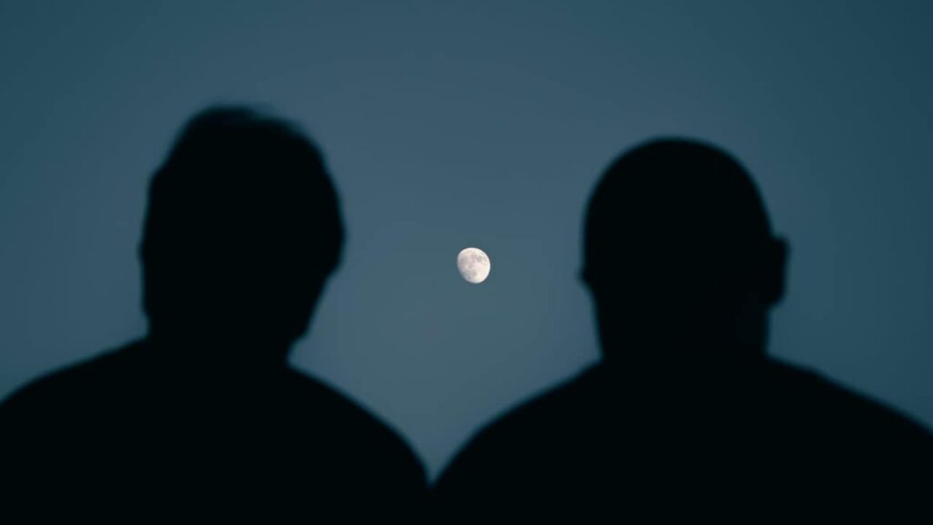 Photo of two people looking at the moon