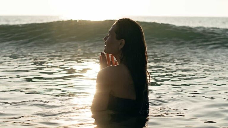 Photo of a woman praying in the water